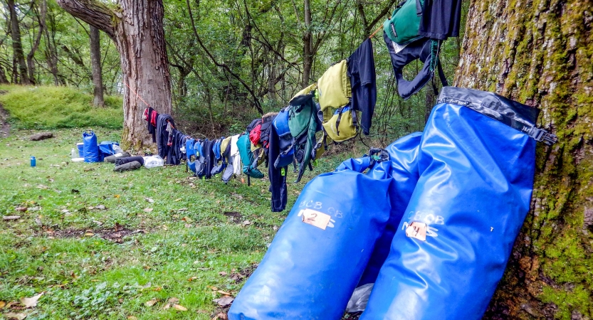 Gear hangs to dry from a clothesline hung between two trees